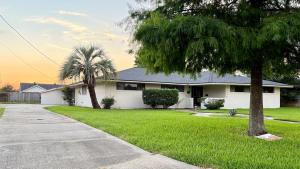 a white house with palm trees in the yard at Sabana in Lake Charles