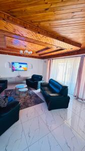 a living room with couches and a flat screen tv at The Golden Palace in Bulawayo