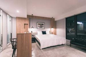 a bedroom with a bed and a desk and a chair at PAPO’A HOTEL in Kaohsiung