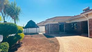 a house with a garden with a hose at The Golden Palace in Bulawayo