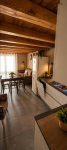 a kitchen and living room with a table and refrigerator at Enfin Clavon - appartamento in baita in Verrayes