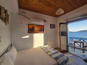 a bedroom with a bed with a view of the ocean at Agla Studio 2 in Fournoi