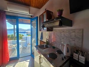 a kitchen with a sink and a view of a balcony at Agla Studio 2 in Fournoi