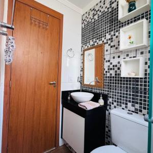 a bathroom with a sink and a toilet and a mirror at Casa Valentina 2 in Catanduva