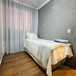 a small bed in a room with a window at Casa Valentina 2 in Catanduva