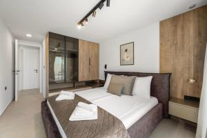 a bedroom with a large bed with two towels on it at Villa Olea Mandalina in Šibenik +36 photos