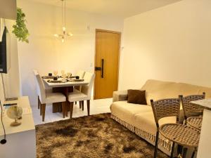 a living room with a table and a couch and a dining room at Apto Com 2 Ar condicionados, Lava e seca, Wi-Fi in Caruaru