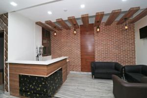 a bar in a lobby with a brick wall at Capital O Esscon House Near Payal Cinema in Gurgaon +31 photos