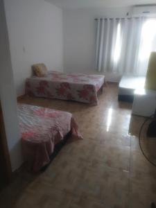 a living room with two beds and a couch at EBORA cultura afro in Ilhéus