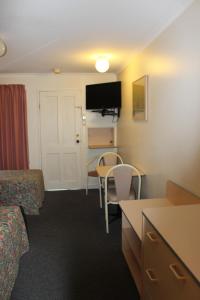 um quarto de hotel com uma cama, uma mesa e cadeiras em Mid Coast Motor Inn em Macksville