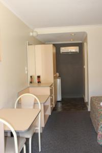 a small room with a table and a bed at Mid Coast Motor Inn in Macksville