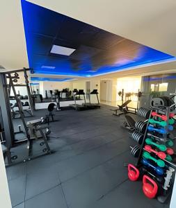 a gym with a blue ceiling and tread machines at Studio Estilo Industrial - 01 - BARRETO - in Mossoró