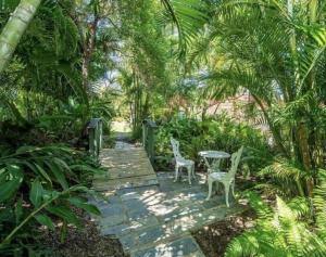 two chairs and a table on a walkway in a garden at 71 Mandalay in Nelly Bay +18 photos