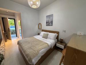 a bedroom with a bed and a chandelier at D-Bay Cabin in Zāwiyat ‘Abd al Mun‘im