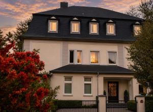 a large white house with a black roof at Ferienwohnung am Saaleknie in Rudolstadt