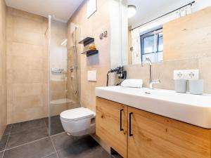 a bathroom with a toilet and a sink and a shower at Tauernlodge Carpe Diem in Niedernsill +26 photos