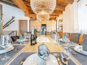 a dining table with wine glasses and a chandelier at Tauernlodge Carpe Diem in Niedernsill