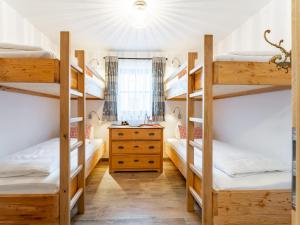 a room with four bunk beds and a dresser at Tauernlodge Carpe Diem in Niedernsill
