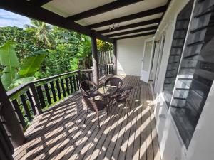 a porch with two chairs and a table on it at Savusavu Terraces - Unit 1 in Savusavu