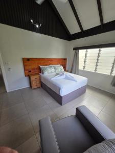a bedroom with a large bed and a window at Savusavu Terraces - Unit 1 in Savusavu