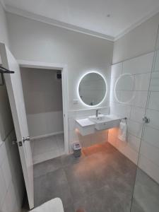 a white bathroom with a sink and a mirror at Savusavu Terraces - Unit 1 in Savusavu +8 photos