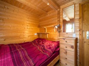 a bed in a log cabin with a wooden wall at Pauls-Hütte in Hippach