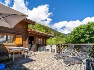 a patio with chairs and a table and an umbrella at Pauls-Hütte in Hippach
