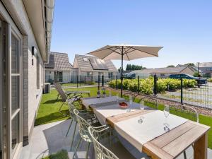 a patio with a table and chairs and an umbrella at Westhinder II H14 in Koksijde