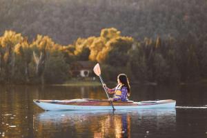 a girl is sitting on a kayak in the water at Chalet au Bord de l'Ecluse in Brébeuf