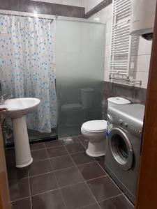 a bathroom with a toilet and a washing machine at Dardi in Peje