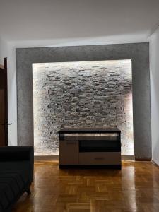 a living room with a brick wall and a couch at Dardi in Peje