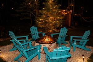 a group of chairs around a fire pit with a christmas tree at Golden Deer Lodge Hot Tub Sauna Sleeps 12 in Tobyhanna +61 photos