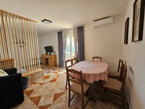 a dining room with a table and chairs in a room at Apartments by the sea Stara Novalja, Pag - 9396 in Novalja