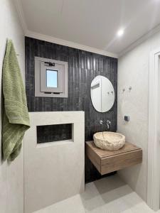 a bathroom with a sink and a mirror at EROS & PATHOS Suites in Kremasti +68 photos