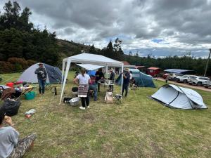 a group of people standing in a field with tents at Camping el triunfo in Montecillo