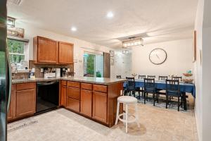 a kitchen with wooden cabinets and a dining room at Golden Deer Lodge Hot Tub Sauna Sleeps 12 in Tobyhanna