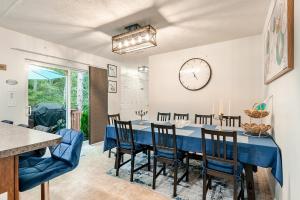 a dining room with a blue table and chairs and a clock at Golden Deer Lodge Hot Tub Sauna Sleeps 12 in Tobyhanna