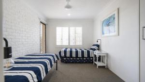 a bedroom with two beds and a window at Flinders Lodge Unit 5 - Lifestyle Yamba in Yamba +12 photos