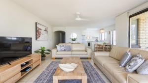 a living room with a couch and a table at Flinders Lodge Unit 1 - Lifestyle Yamba in Yamba