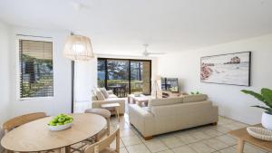 a living room with a couch and a table at Flinders Lodge Unit 1 - Lifestyle Yamba in Yamba