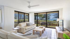 a living room with a couch and a table at Flinders Lodge Unit 1 - Lifestyle Yamba in Yamba