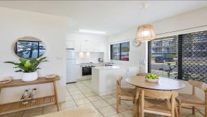 a kitchen and dining room with a table and chairs at Flinders Lodge Unit 1 - Lifestyle Yamba in Yamba +15 photos