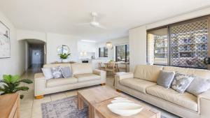 a living room with two couches and a table at Flinders Lodge Unit 1 - Lifestyle Yamba in Yamba