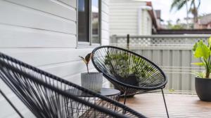 a chair sitting on a porch with a plant at Leonards Beachshack - Lifestyle Yamba in Yamba