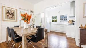 a kitchen and dining room with a wooden table and chairs at Leonards Beachshack - Lifestyle Yamba in Yamba