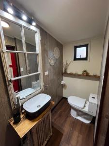 a bathroom with a sink and a toilet and a window at Casita Loica in Chaitén