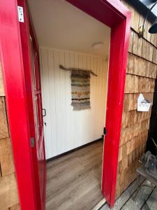 an open red door in a room with a wall at Casita Loica in Chaitén