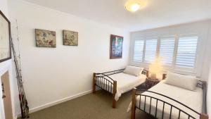 a bedroom with two twin beds and a window at Lighthouse Unit 1 - Lifestyle Yamba in Yamba