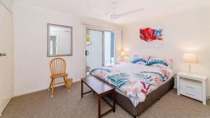 a bedroom with a bed and a desk and a chair at Lighthouse Unit 1 - Lifestyle Yamba in Yamba