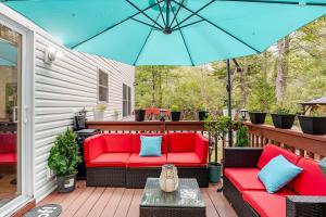 a patio with red chairs and a blue umbrella at Golden Deer Lodge Hot Tub Sauna Sleeps 12 in Tobyhanna